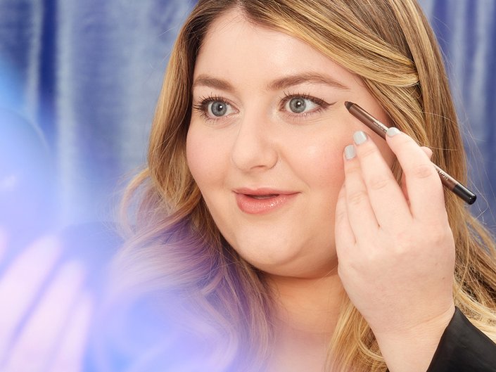 A closeup of someone applying brown eyeliner for a brown eyeliner look