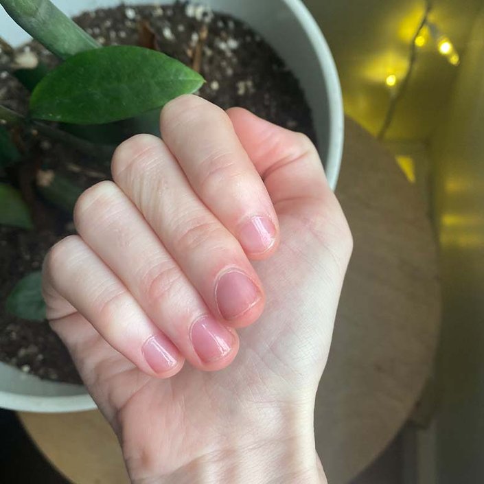 hand with clear nail polish on nails