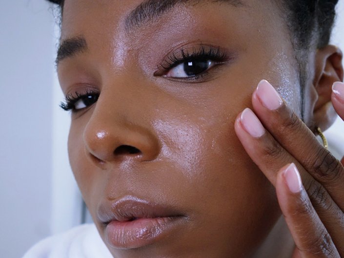 person massaging sunscreen into cheek