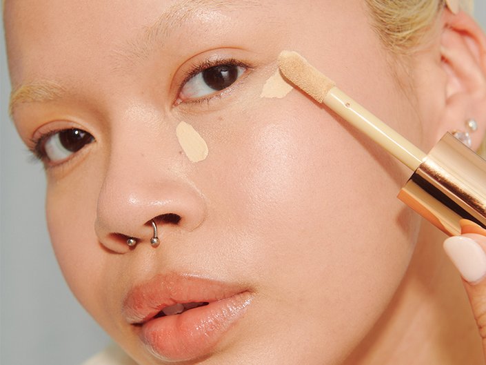 person applying concealer under their eye area