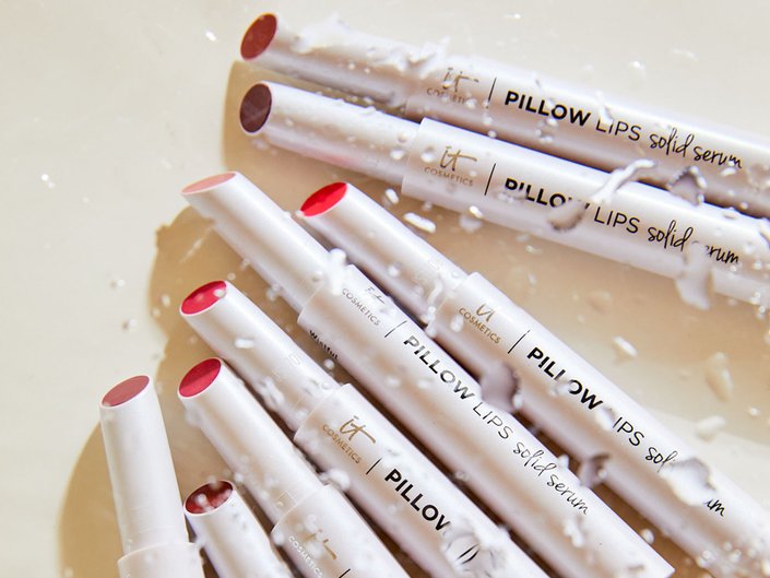 Flat lay of various shades of the IT Cosmetics Pillow Lips Solid Serum Lip Gloss