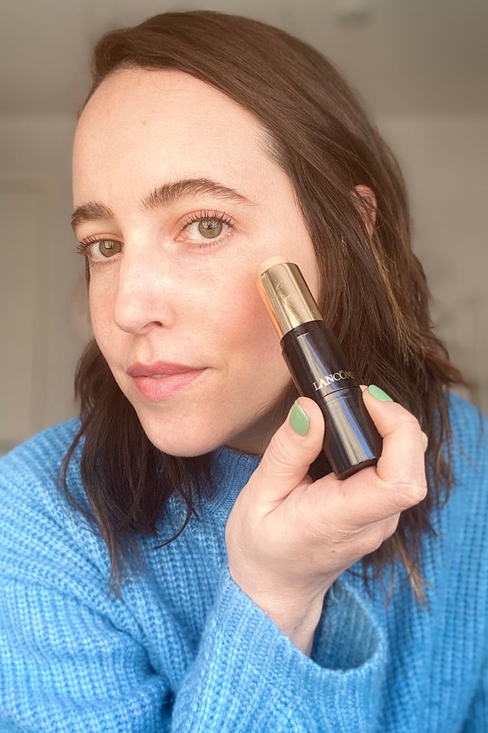person applying lancome teint idole foundation stick to face
