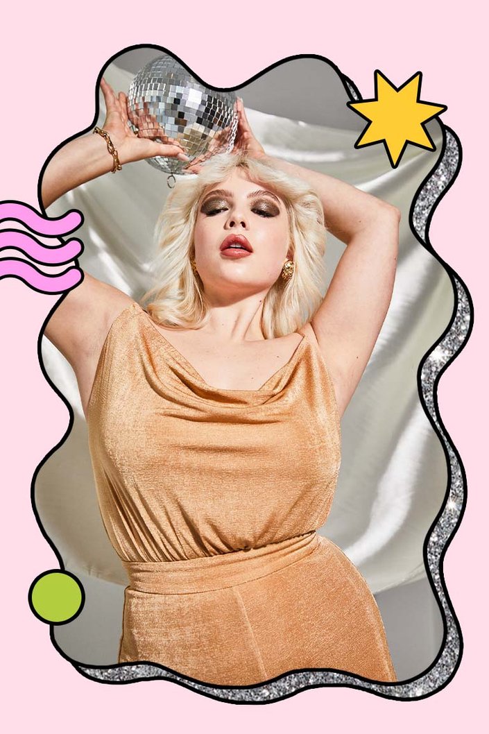 person wearing smokey green eyeshadow and holding disco ball over head