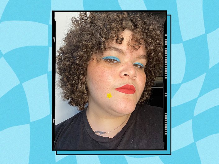 A person with curly hair wearing blue eyeshadow